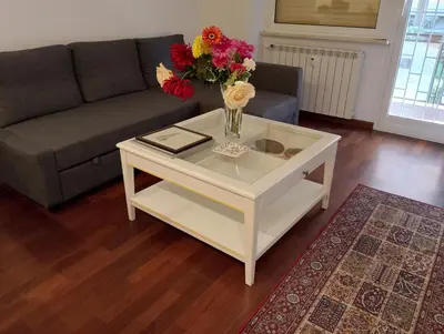 a living room with a vase of flowers on a coffee table at Casa 12 in Rome