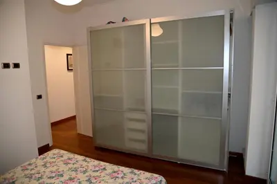 a large closet with glass doors in a room at Casa 12 in Rome