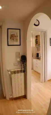 a living room with an archway and a kitchen at Appartamento Cornelia near San Pietro in Rome