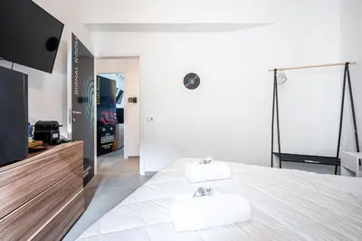 a white bedroom with two towels on a bed at Roman Waves Room - 2 MIN Metro Marconi - 15 MIN Colosseo - A-C & WIFI in Rome