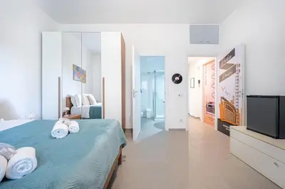 a bedroom with a blue bed and a television at Roman Waves Room - 2 MIN Metro Marconi - 15 MIN Colosseo - A-C & WIFI in Rome