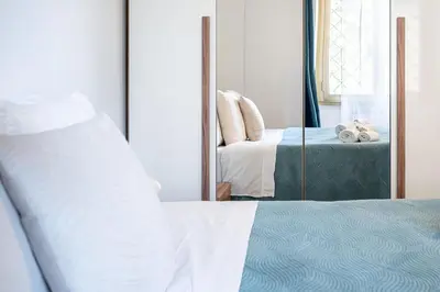 a bedroom with a bed and a mirror at Roman Waves Room - 2 MIN Metro Marconi - 15 MIN Colosseo - A-C & WIFI in Rome