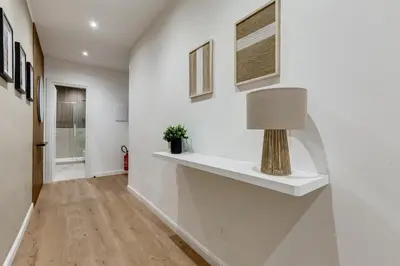 a hallway with white walls and a lamp on a shelf at Scipioni Luxury Apartment in Rome