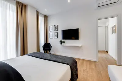 a bedroom with a bed and a tv on a wall at Scipioni Luxury Apartment in Rome