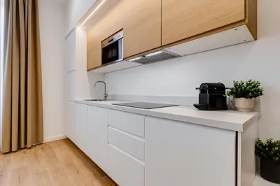 a kitchen with white cabinets and a sink at Scipioni Luxury Apartment in Rome