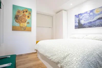 a bedroom with a bed and a painting on the wall at Troppo Forte appartamento a due passi dal Colosseo in Rome