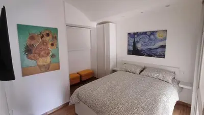 a bedroom with a bed and two paintings on the wall at Troppo Forte appartamento a due passi dal Colosseo in Rome