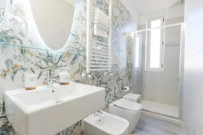 a bathroom with a sink and a toilet and a mirror at 10 Min from Termini Sisters Cozy Rome Apartment in Rome