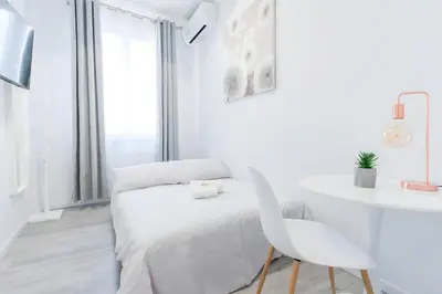 a white bedroom with a white bed and a white desk at 10 Min from Termini Sisters Cozy Rome Apartment in Rome