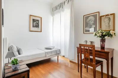 a bedroom with a bed and a desk and a chair at La Dimora dell'Antiquario in Rome