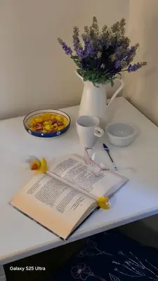 a table with an open book and a vase with flowers at Casa Orietta in Rome