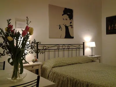 a bedroom with a bed and a vase of flowers on a table at B&B Trastevere in Bed in Rome