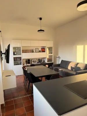 a kitchen and living room with a table and a couch at The Monteverde Penthouse in Rome