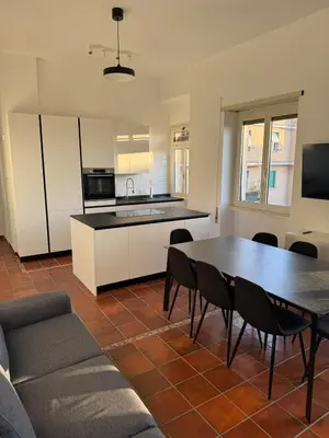 a living room with a table and a kitchen at The Monteverde Penthouse in Rome