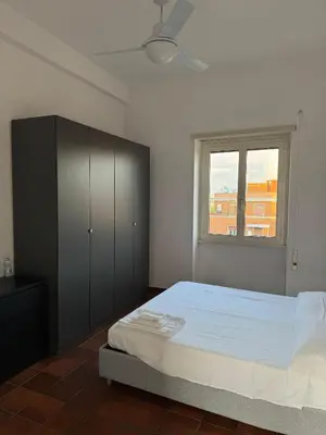 a bedroom with a large bed and a window at The Monteverde Penthouse in Rome