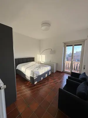 a bedroom with a bed and a couch at The Monteverde Penthouse in Rome