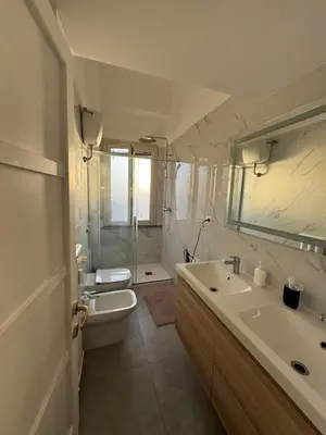 a bathroom with a sink and a toilet and a mirror at The Monteverde Penthouse in Rome