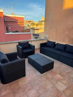 a patio with chairs and couches on a rooftop at The Monteverde Penthouse in Rome