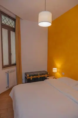 a bedroom with a large white bed and a lamp at Appartamento Rea Silvia in Rome