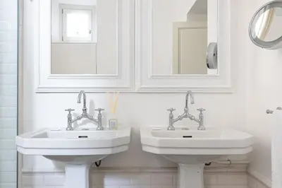two sinks in a white bathroom with two mirrors at Casa Giulia, a Burghesius home in Rome