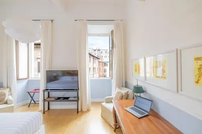 a white living room with a laptop on a table at Casa Giulia, a Burghesius home in Rome