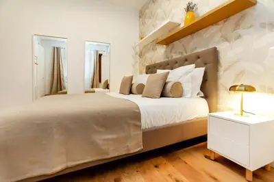 a bedroom with a large bed and a white night stand at Dimora Cavallini in Rome
