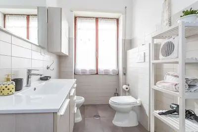 a white bathroom with a toilet and a sink at St Peter apartment with Garage in Rome