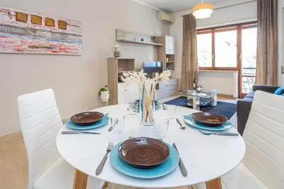 a white dining room with a white table and chairs at St Peter apartment with Garage in Rome