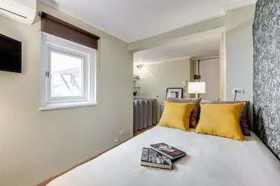 a bedroom with a bed with yellow pillows and a window at La Casina your suite in Monti in Rome