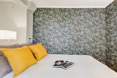 a bedroom with a bed with yellow pillows and a wall at La Casina your suite in Monti in Rome