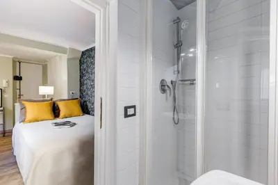 a bedroom with a bed and a shower at La Casina your suite in Monti in Rome