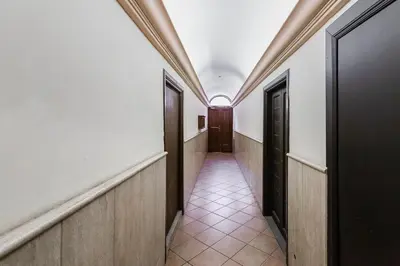 a corridor of an office building with doors and tiles at La Casina your suite in Monti in Rome