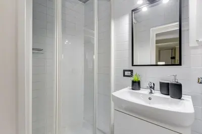 a white bathroom with a sink and a shower at La Casina your suite in Monti in Rome