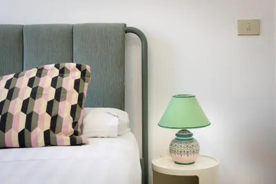 a lamp sitting on a table next to a bed at Casa Assunta in Rome