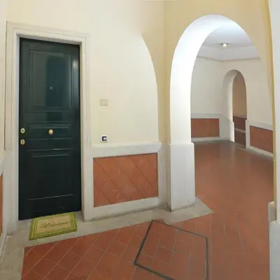 a hallway with a black door and a tile floor at Vittoria Charme in Rome