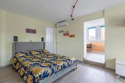 a bedroom with a bed with a blue and yellow blanket at San Paolo - 10 min from Metro and 30 mq Terrace in Rome