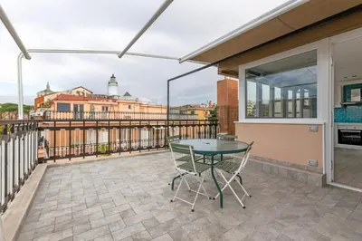 a patio with a table and chairs on a balcony at San Paolo - 10 min from Metro and 30 mq Terrace in Rome