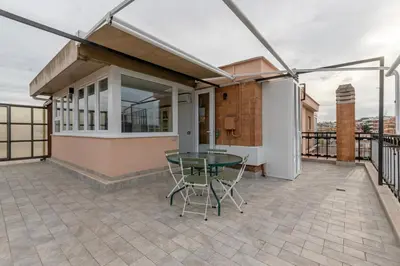 a patio with a table and chairs on a balcony at San Paolo - 10 min from Metro and 30 mq Terrace in Rome