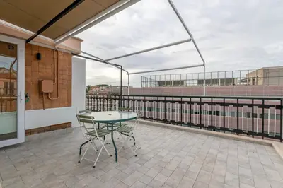 a patio with a glass table and chairs on a balcony at San Paolo - 10 min from Metro and 30 mq Terrace in Rome
