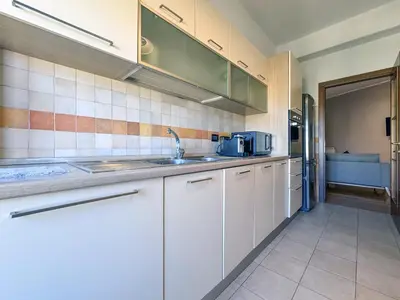 a kitchen with white cabinets and a sink at Escher's Penthouse on Nomentana in Rome