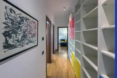 a hallway with shelves and a painting on the wall at Escher's Penthouse on Nomentana in Rome
