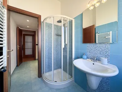 a blue bathroom with a sink and a shower at Escher's Penthouse on Nomentana in Rome