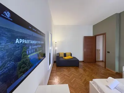 a living room with a large poster on the wall at Escher's Penthouse on Nomentana in Rome
