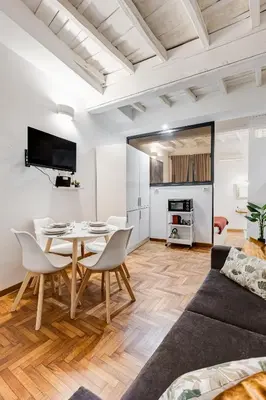 a living room with a table and chairs and a couch at Trastevere One by GHOR in Rome