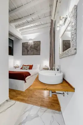 a bedroom with a bed and a tub and a sink at Trastevere One by GHOR in Rome