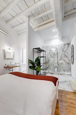 a bedroom with a large white bed and a plant at Trastevere One by GHOR in Rome