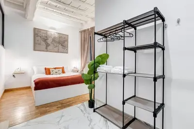 a room with a bed and a black book shelf at Trastevere One by GHOR in Rome