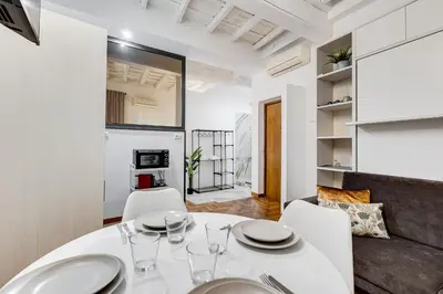a dining room with a white table and chairs at Trastevere One by GHOR in Rome