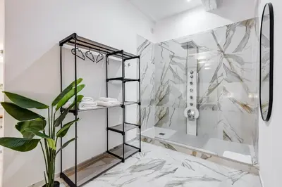 a bathroom with a shower and a plant at Trastevere One by GHOR in Rome