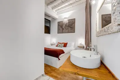 a bathroom with a bed and a tub in a room at Trastevere One by GHOR in Rome